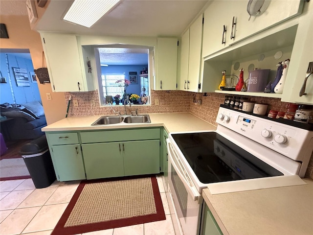kitchen with green cabinetry, a sink, light countertops, white electric range, and tasteful backsplash