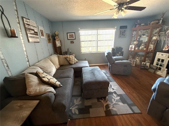 living room with wood finished floors, a textured ceiling, and ceiling fan