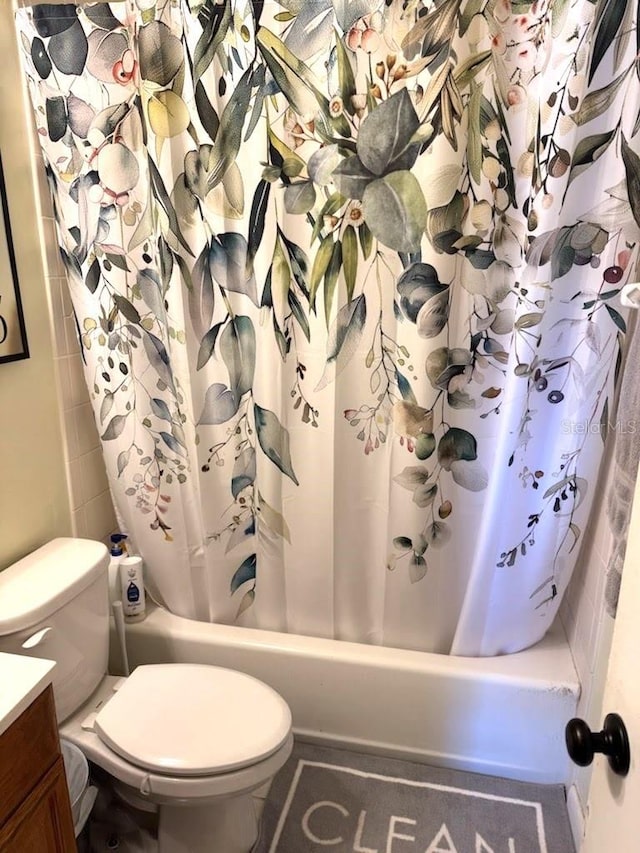 bathroom featuring vanity, shower / tub combo, and toilet