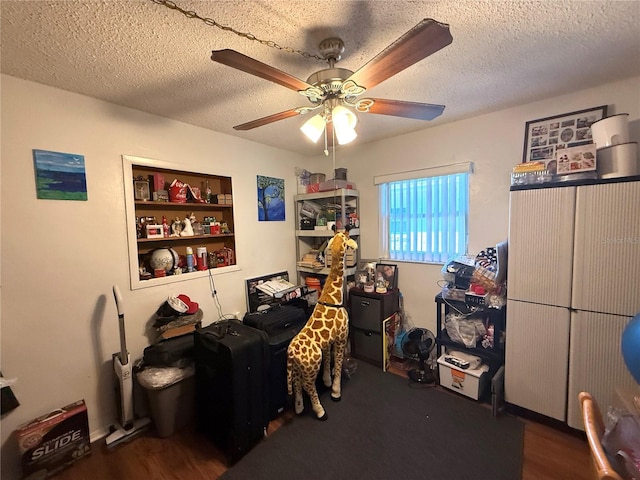 bedroom with a textured ceiling, a ceiling fan, and wood finished floors
