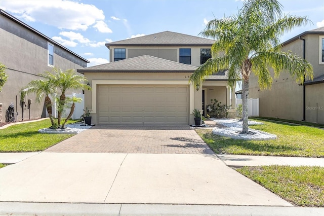 11895 Crestridge Loop, New Port Richey, FL 34655 - view of front of property featuring stucco siding, roof with shingles, decorative driveway, a front lawn, and a garage