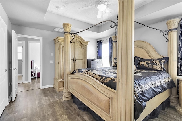 11895 Crestridge Loop, New Port Richey, FL 34655 - bedroom with a textured ceiling, visible vents, baseboards, a ceiling fan, and dark wood finished floors