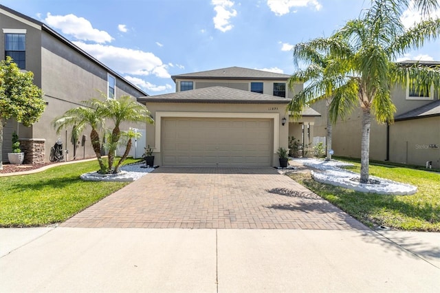 11895 Crestridge Loop, New Port Richey, FL 34655 - view of front of house featuring a front yard, decorative driveway, stucco siding, and an attached garage