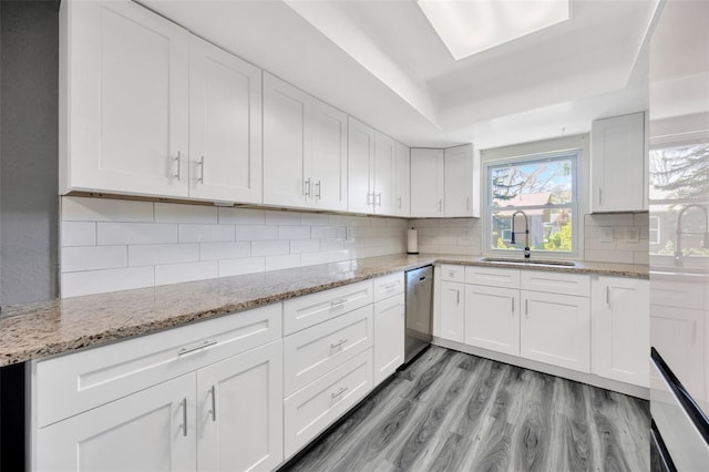 8626 White Springs Dr, New Port Richey, FL 34655 - kitchen with backsplash, light wood-style flooring, a sink, and stainless steel dishwasher