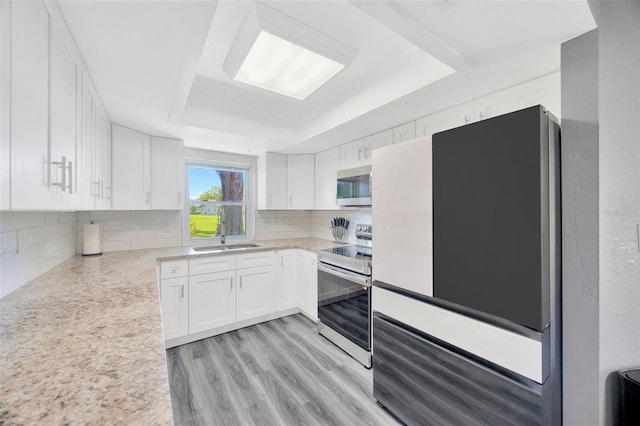 8626 White Springs Dr, New Port Richey, FL 34655 - kitchen with light countertops, stainless steel appliances, tasteful backsplash, a sink, and a tray ceiling