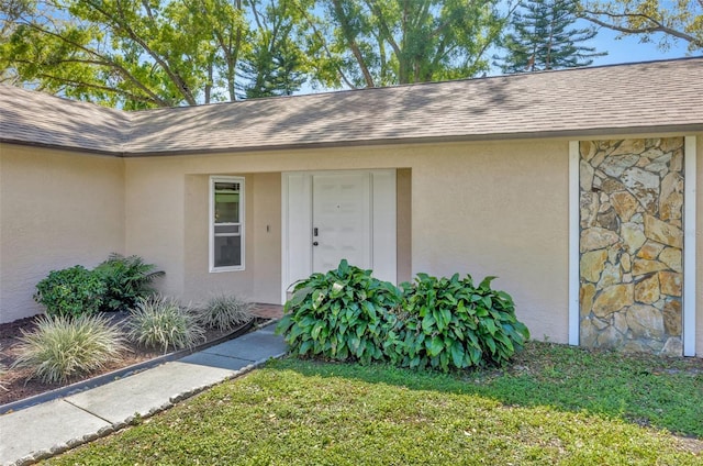 8626 White Springs Dr, New Port Richey, FL 34655 - entrance to property with a shingled roof, stucco siding, and stone siding