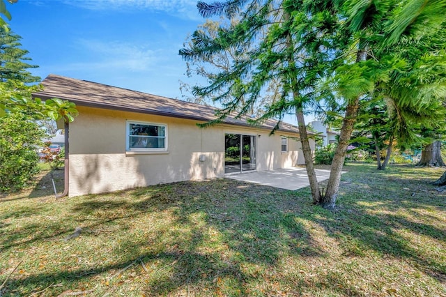 8626 White Springs Dr, New Port Richey, FL 34655 - rear view of house with stucco siding, a lawn, and a patio