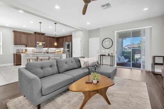 living area with wood finished floors, ceiling fan, baseboards, visible vents, and recessed lighting