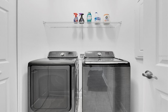 clothes washing area featuring washing machine and clothes dryer and laundry area