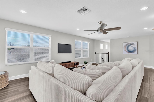 living area featuring baseboards, a ceiling fan, wood finished floors, and visible vents