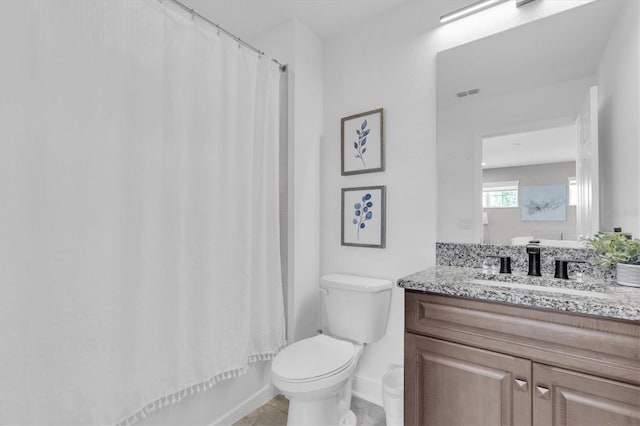bathroom featuring shower / bath combo, toilet, baseboards, visible vents, and vanity