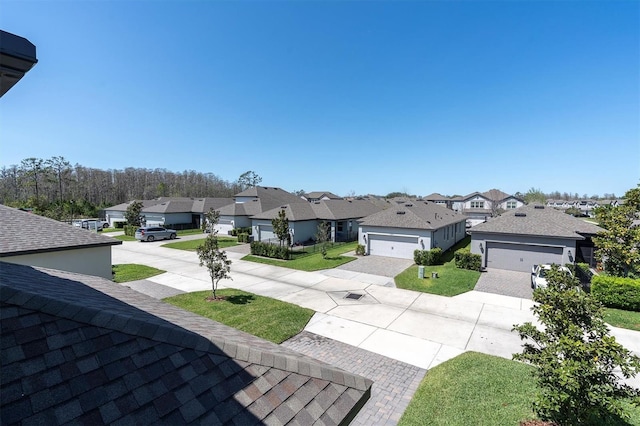 view of yard featuring decorative driveway and a residential view