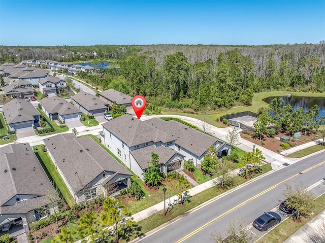 aerial view featuring a water view, a residential view, and a wooded view
