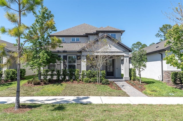 view of front of home featuring stucco siding and a front lawn