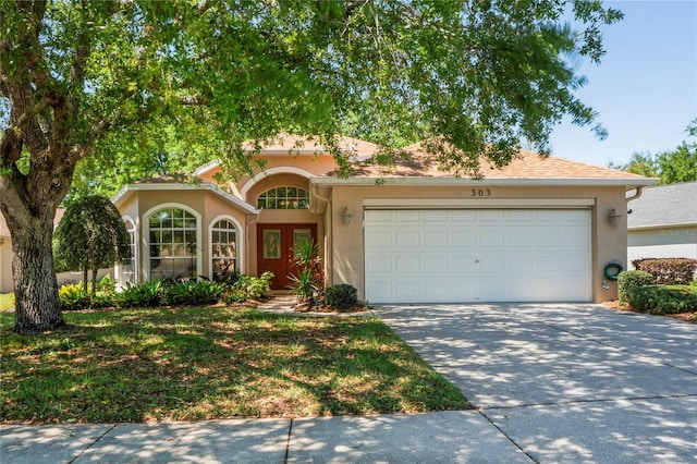 303 Rochester St, Spring Hill, FL 34609 - view of front of home with stucco siding, driveway, and a garage