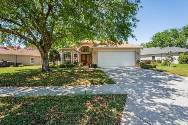 303 Rochester St, Spring Hill, FL 34609 - view of front of house featuring a front yard, an attached garage, driveway, and stucco siding