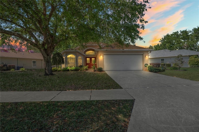 303 Rochester St, Spring Hill, FL 34609 - view of front facade with stucco siding, driveway, a front yard, and a garage