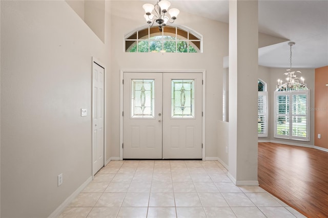 303 Rochester St, Spring Hill, FL 34609 - foyer entrance with light tile patterned flooring, a notable chandelier, baseboards, and a towering ceiling