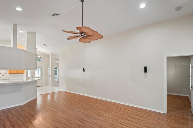 303 Rochester St, Spring Hill, FL 34609 - unfurnished living room with visible vents, baseboards, light wood-type flooring, high vaulted ceiling, and a ceiling fan