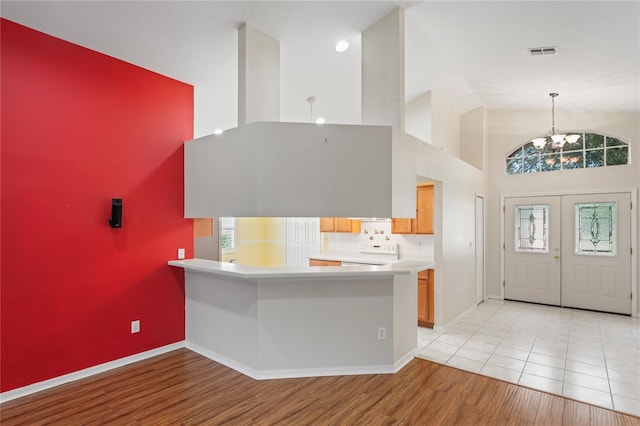 303 Rochester St, Spring Hill, FL 34609 - kitchen with visible vents, high vaulted ceiling, an inviting chandelier, light countertops, and range
