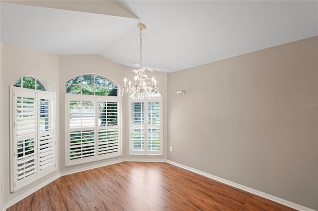 303 Rochester St, Spring Hill, FL 34609 - empty room with a chandelier, baseboards, lofted ceiling, and wood finished floors