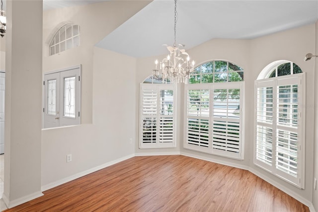 303 Rochester St, Spring Hill, FL 34609 - unfurnished dining area with a notable chandelier, baseboards, lofted ceiling, and wood finished floors