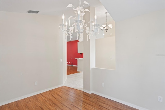 303 Rochester St, Spring Hill, FL 34609 - empty room featuring visible vents, a notable chandelier, wood finished floors, and baseboards