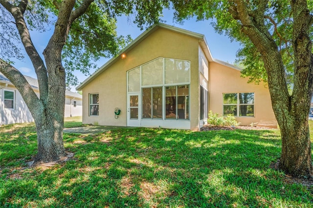 303 Rochester St, Spring Hill, FL 34609 - rear view of property with stucco siding, a lawn, and a sunroom
