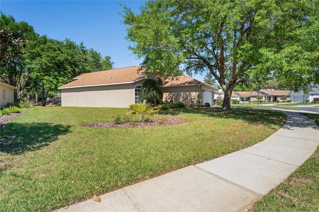 303 Rochester St, Spring Hill, FL 34609 - exterior space with stucco siding, a lawn, and an attached garage