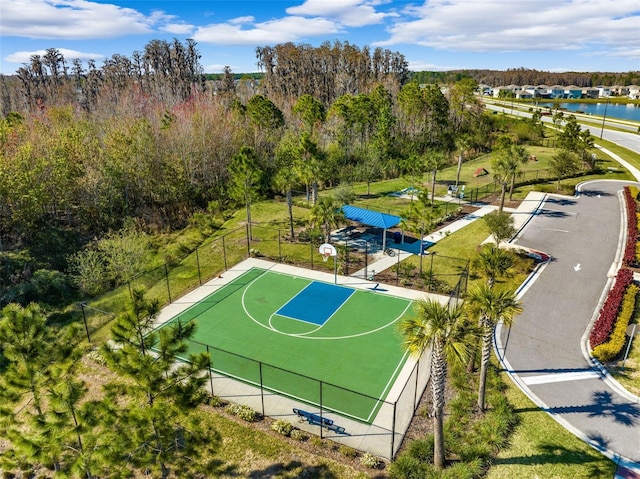 view of sport court with community basketball court, a lawn, a water view, and fence