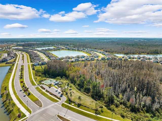 drone / aerial view featuring a water view and a view of trees