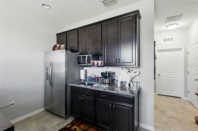 kitchen with visible vents, appliances with stainless steel finishes, and dark stone counters