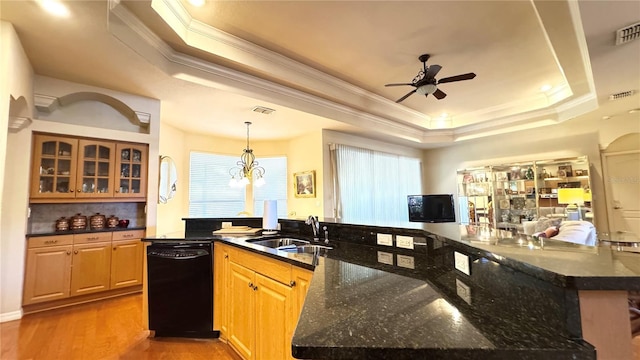 kitchen featuring black dishwasher, a ceiling fan, a sink, and a raised ceiling