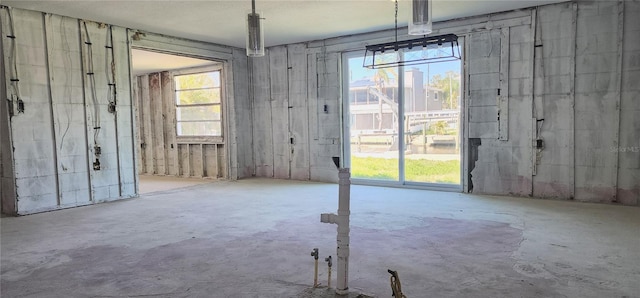 unfurnished dining area featuring a wealth of natural light and concrete floors