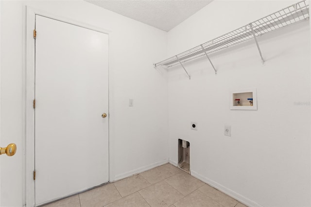 laundry area with electric dryer hookup, washer hookup, baseboards, and light tile patterned flooring