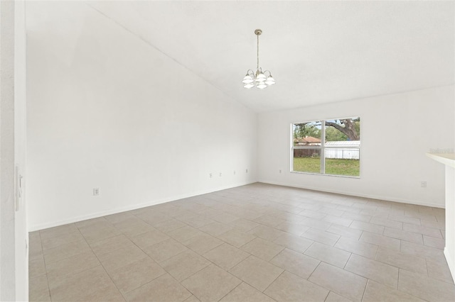 empty room with a chandelier, vaulted ceiling, light tile patterned floors, and baseboards