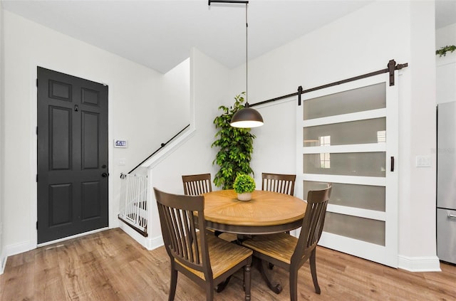 10623 Marsha Dr, New Port Richey, FL 34655 - dining space with a barn door, wood finished floors, and baseboards