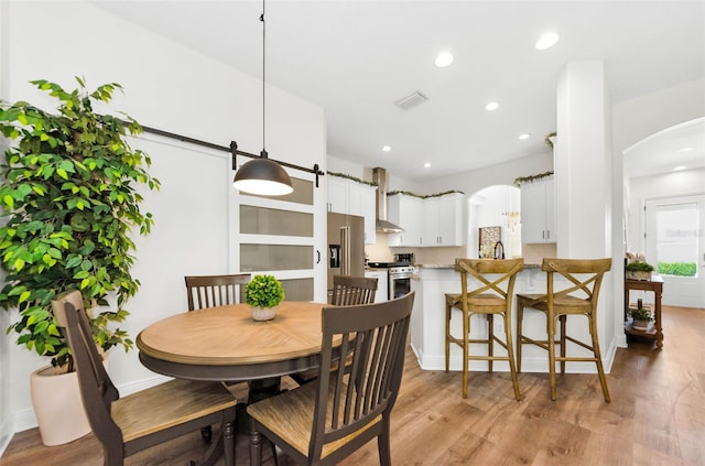 10623 Marsha Dr, New Port Richey, FL 34655 - dining area with arched walkways, light wood finished floors, recessed lighting, and baseboards