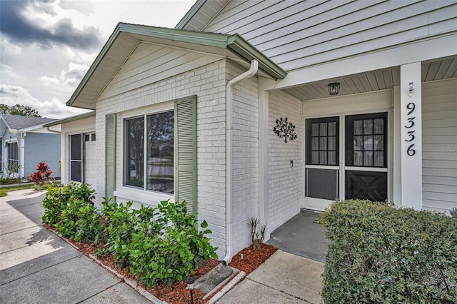 view of exterior entry with brick siding