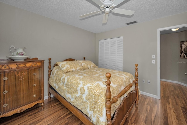 bedroom with a textured ceiling, a closet, wood finished floors, and visible vents