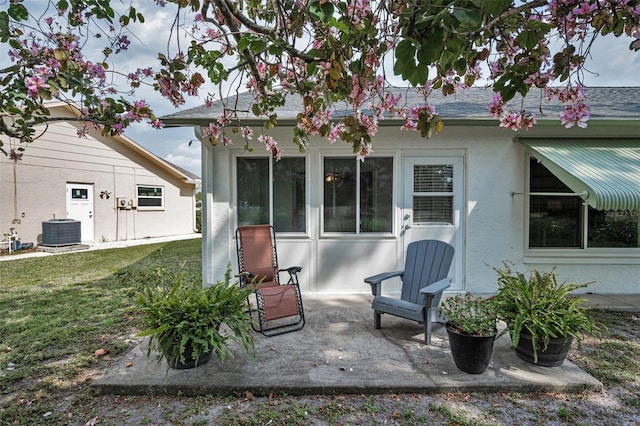 back of house with a lawn, a patio, stucco siding, and cooling unit
