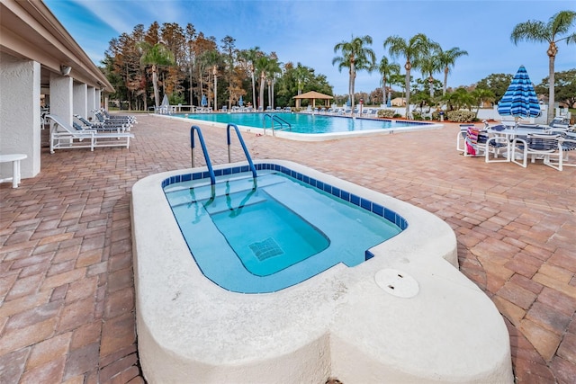 pool featuring a community hot tub and a patio area