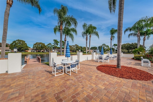 exterior space with a water view and outdoor dining space