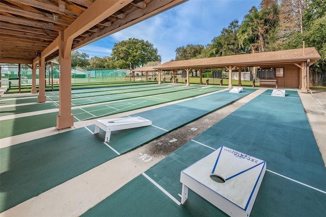 surrounding community with fence and shuffleboard