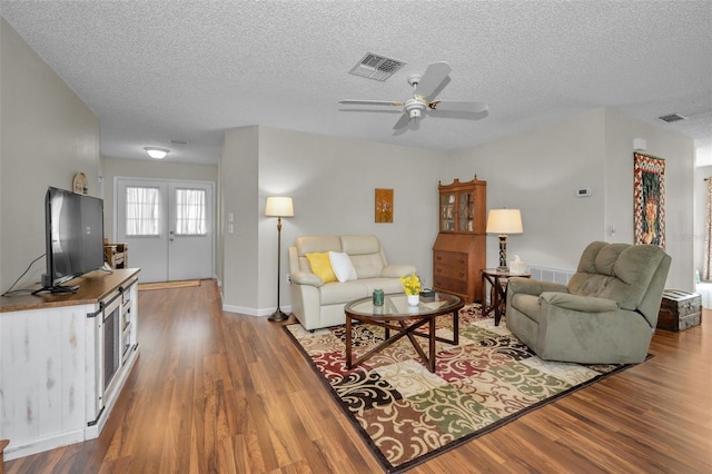 living room featuring ceiling fan, wood finished floors, and visible vents