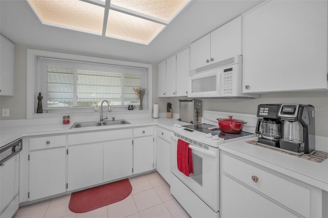 kitchen featuring a sink, light tile patterned floors, white cabinets, and white appliances