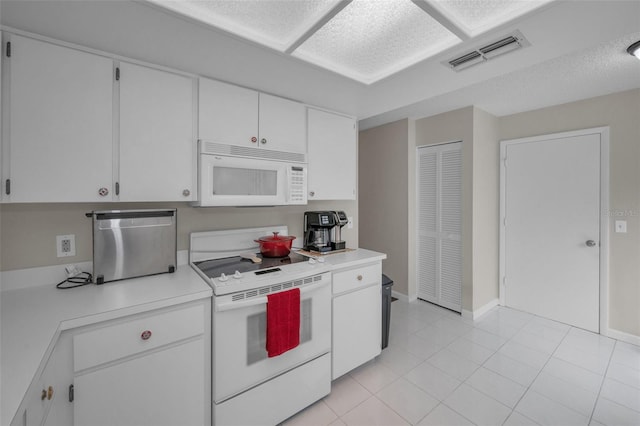 kitchen with visible vents, light countertops, white cabinets, white appliances, and light tile patterned flooring