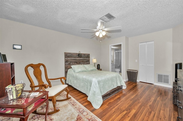 bedroom with a textured ceiling, baseboards, visible vents, and wood finished floors