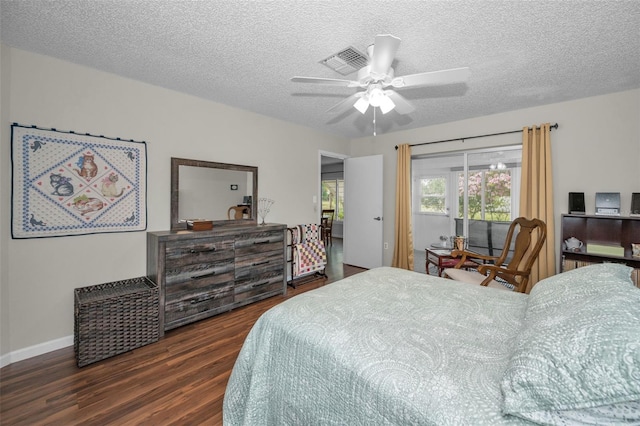 bedroom with a ceiling fan, a textured ceiling, visible vents, wood finished floors, and baseboards