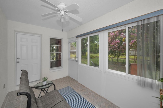 unfurnished sunroom with a ceiling fan